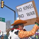 A protester dressed as Woody protests kings and wars.