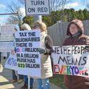 A protester points out how much money those in power have.