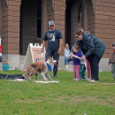 A mother helps her daughter throw a frisbee for Chaos. 