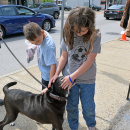 Evelyn, 10, and Colton, 7 pet a passing dog.