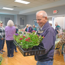A man very happy with his purchase of plants at the Oak Point plant sale. 