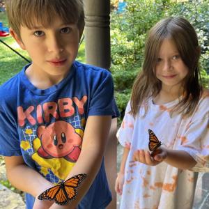 Oscar (left) and Lark Hurley hold the butterflies they raised from caterpillars. 