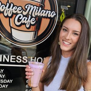 Hope Anderson stands outside Coffee Milano Cafe holding a purple cold brew. Photo source: Lorna Brunelle Hope Anderson stands outside Coffee Milano Cafe holding a purple cold brew.