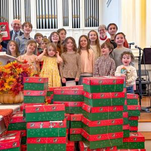 Volunteers stand with the gift boxes they packed at Central Congressional Church. Photo source: Central Congressional Church