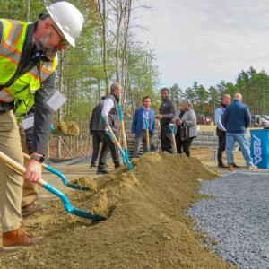 One of the project contractors shovels dirt at the ceremony. 