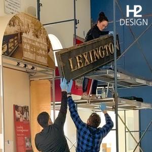 Hansen, center, installs a sign in the exhibit she and her mother designed. 
