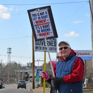 A man proudly holds his sign for all to see.