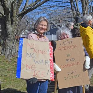 Two protesters pose with their signs.