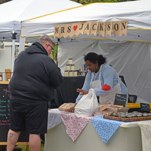 A baker talks to a customer about her baked goods. 