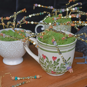 A teacup filled with beaded trees. 