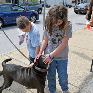 Evelyn, 10, and Colton, 7 pet a passing dog.