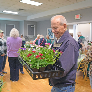 A man very happy with his purchase of plants at the Oak Point plant sale. 