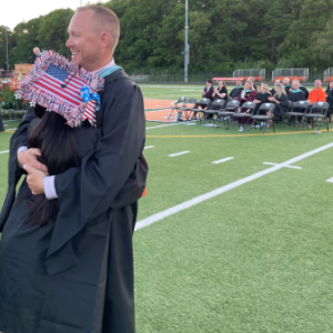 Middleboro High School Assistant Principal Andrew Dizel hugs a student at a previous graduation. File photo