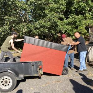 Cash gets help from some friends to replace the donation bin. 