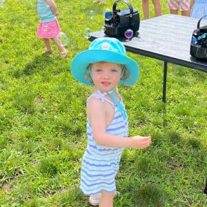 Penny Schuler, 2, poses in front of the bubble blowers. Photo by Christian Uva