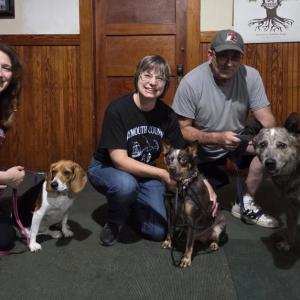 Dog trainers Cristina Fredette and Sherri Swindle, as well as Swindle’s husband, pose with their dogs. 
