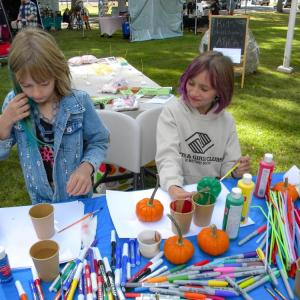 Sisters Lyla, 7, left, and Cheyenne, 9, right, paint pumpkins.