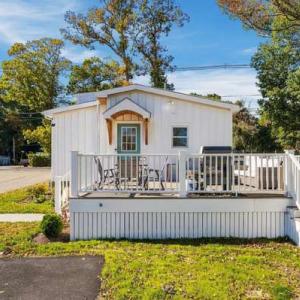Composite front deck with seating and a grill outside the teal front door of 226 Sanford Road, Westport, MA