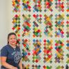 Michelle Medeiros poses with her scrap-fabric quilt inside Homestead Quilting and Fabric on Oct. 12.