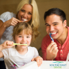 Smiling family brushing their teeth