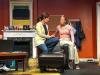 Two actors are onstage talking. 